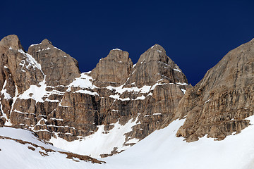 Image showing Rocks in snow and blue cloudless sky