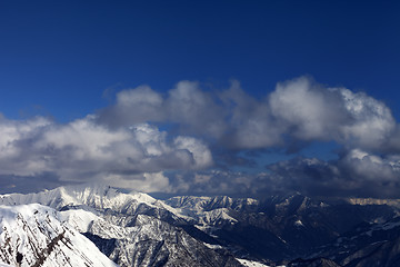 Image showing Winter sunlit mountains and sky with clouds