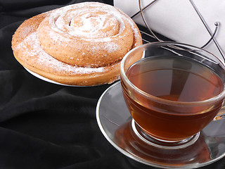 Image showing Hot tea with sweet cake on black background