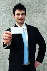 Image showing Businessman holds a blank card - add your own text.