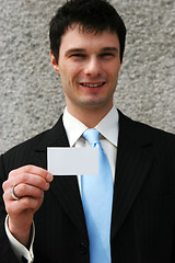 Image showing Businessman holds a blank card - add your own text.