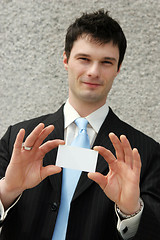 Image showing Businessman holds a blank card - add your own text.