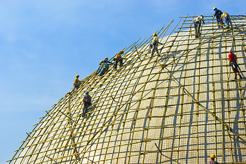 Image showing Closeup of construction worker assembling scaffold on building s