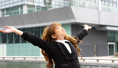 Image showing Woman relaxing with arms open enjoying her freedom and office bu