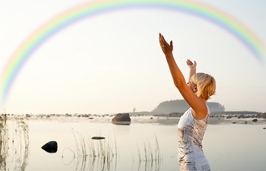 Image showing pretty blond raising hands to the rainbow