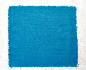 Image showing blue napkin on white wooden table