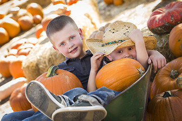 Image showing Two Little Boys Playing in Wheelbarrow at the Pumpkin Patch
