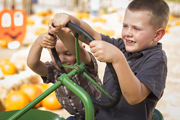 Image showing Adorable Young Boys Playing on an Old Tractor Outside