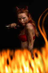 Image showing dark red devil girl with a knife in fire