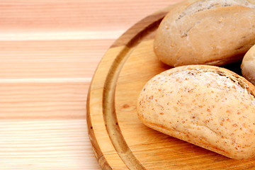 Image showing Closeup of fresh bread rolls on a wooden board