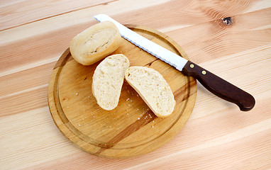 Image showing Fresh rolls, whole and halved, with bread knife