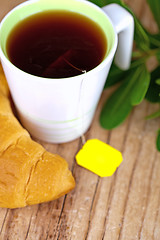 Image showing cup of tea and fresh croissant 