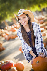 Image showing Preteen Girl Playing with a Wheelbarrow at the Pumpkin Patch
