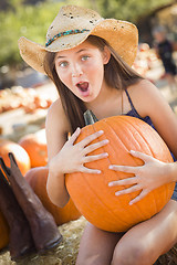 Image showing Preteen Girl Holding A Large Pumpkin at the Pumpkin Patch
