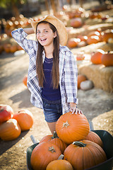 Image showing Preteen Girl Playing with a Wheelbarrow at the Pumpkin Patch
