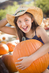 Image showing Preteen Girl Holding A Large Pumpkin at the Pumpkin Patch
