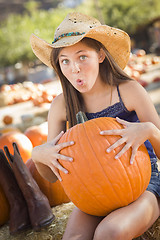 Image showing Preteen Girl Holding A Large Pumpkin at the Pumpkin Patch
