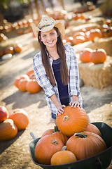 Image showing Preteen Girl Playing with a Wheelbarrow at the Pumpkin Patch
