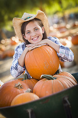 Image showing Preteen Girl Playing with a Wheelbarrow at the Pumpkin Patch
