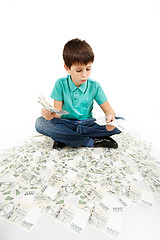 Image showing boy sitting on money