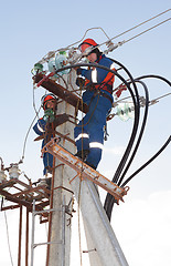 Image showing Electricians in blue overalls working at height