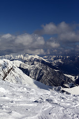 Image showing Sunlit mountains in clouds, view from off-piste slope
