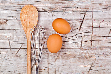 Image showing spoon, wire whisk and two brown eggs