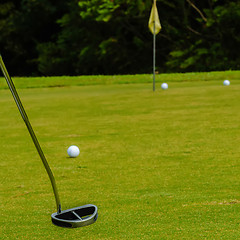 Image showing Golf ball on a green, in front of the hole,