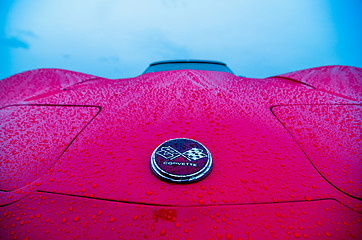 Image showing red sports car wet from rain drops