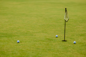 Image showing Golf ball on a green, in front of the hole,