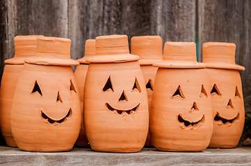 Image showing clay pumpkins standing happy near the wood fence