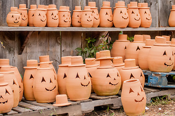 Image showing clay pumpkins standing happy near the wood fence