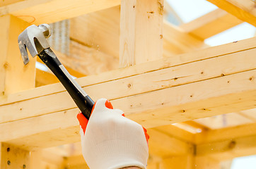 Image showing worker hammering nails to wood studs