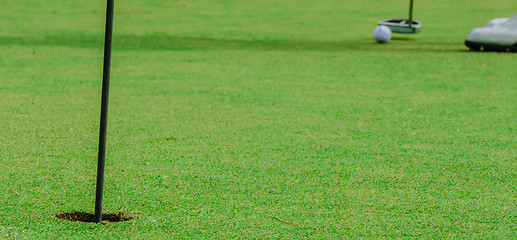 Image showing Golf ball on a green, in front of the hole,