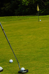 Image showing Golf ball on a green, in front of the hole,