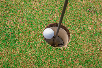 Image showing Golf ball on a green, in front of the hole,