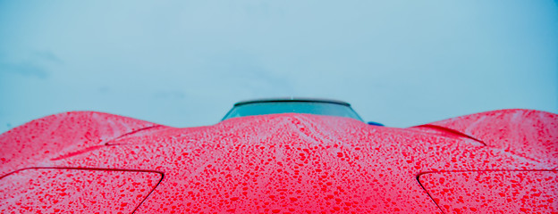 Image showing red sports car wet from rain drops