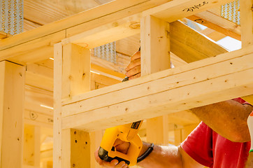 Image showing Building contractor worker using a reciprocating saw to cut 