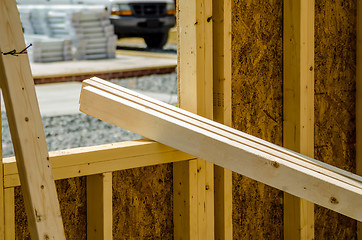 Image showing stack of wood stud planks at construction site resting on window