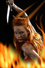 Image showing red devil girl with a knife in fire