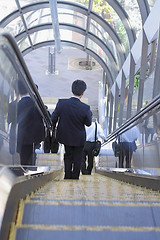 Image showing Businessman on moving staircase
