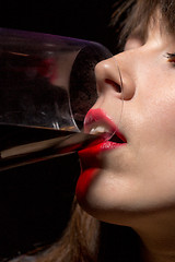 Image showing Young woman drinking red wine from a glass