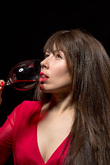 Image showing Young woman drinking red wine from a glass