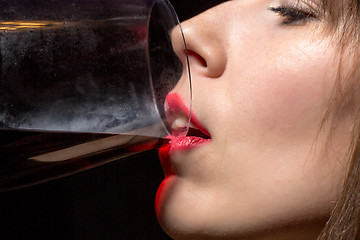 Image showing Young woman drinking red wine from a glass