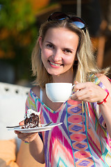 Image showing girl with a cup of coffee and cake
