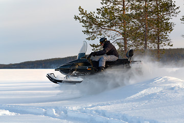 Image showing man riding a snowmobile