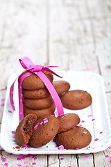 Image showing fresh chocolate cookies with pink ribbon and confetti 