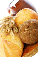 Image showing Bread, wheat ears and milk in a clay mug.