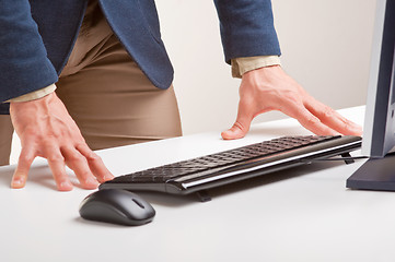 Image showing Man Standing and Looking At A Computer Monitor