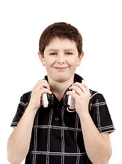 Image showing Portrait of a happy smiling young boy listening to music on head